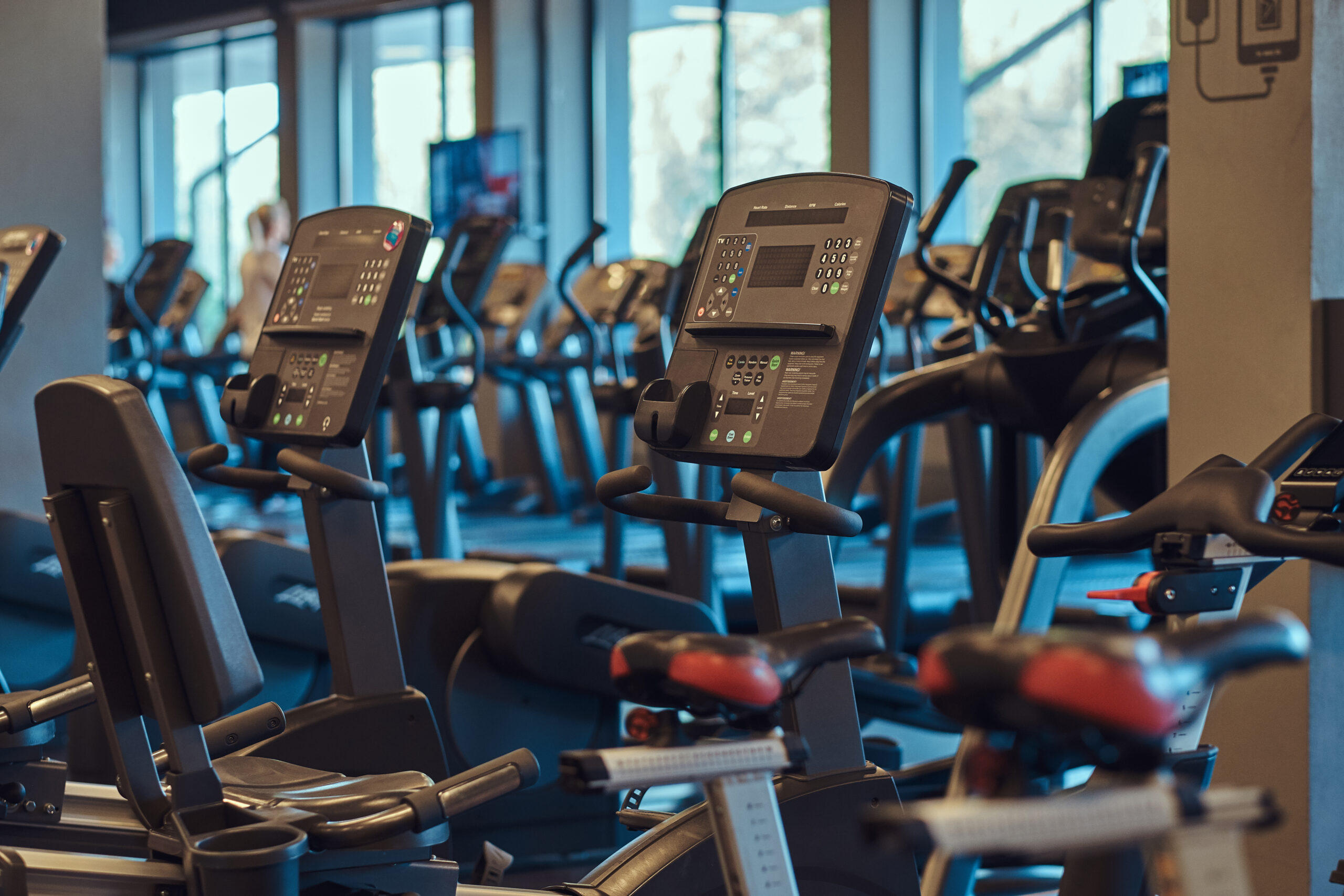 Modern equipment in a gym indoors. Interior of fitness hall with fitness bicycles.